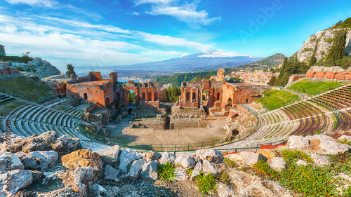 Ruins of ancient Greek theater in Taormina and Etna volcano in the background. photo