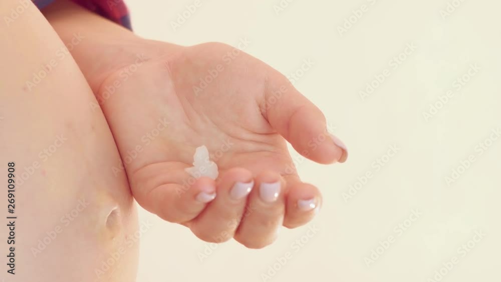 A pregnant woman squeezes the cream on her hands. Bright room. Colse up shot A pregnant woman squeezes the cream on her hands. Bright room. Colse up shot