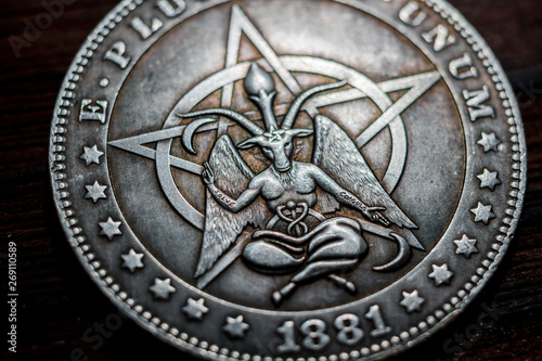 Souvenir coin with the image of a baphomet close-up. Inscription Solve Coagula on Latin