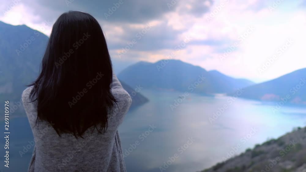 back view woman traveller taking pictures amazing nature in mountains area. brunette using smartphone for shooting during vacation cloudy skyline over the sea back view woman traveller taking pictures amazing nature in mountains area. brunette using smartphone for shooting during vacation cloudy skyline over the sea