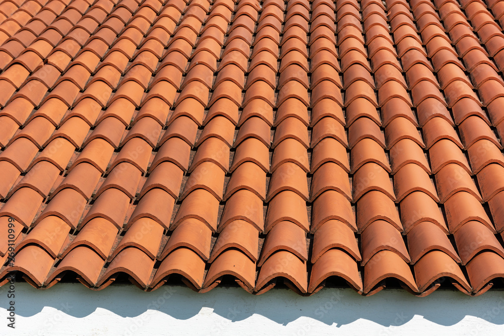 Red corrugated tile element of the roof at the house and white wall. Shingles roofing surface tiles overlay pattern and texture Red corrugated tile element of the roof at the house and white wall. Shingles roofing surface tiles overlay pattern and texture