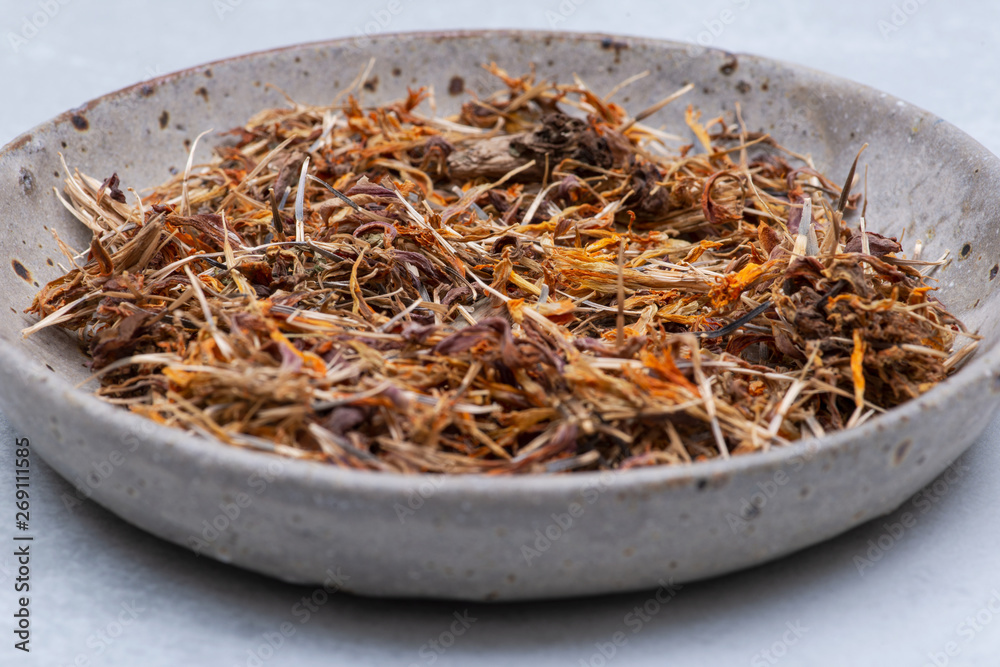 Marigold Dry Seeds (Mexican marigold, Aztec marigold, African marigold) in ceramic plate on gray  background. Tagetes erecta. Daisy family.