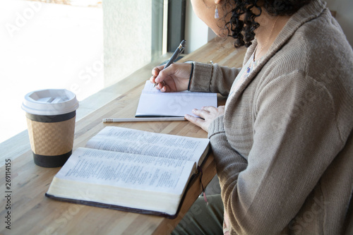 woman makes notes while she studies her bible 