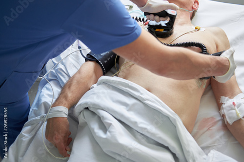Doctor intensivist performs defibrillation to critical patient
