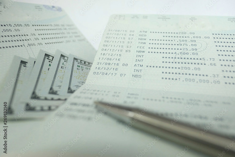 Bank account ballance passbook with pen and dollar banknote on white background Bank account ballance passbook with pen and dollar banknote on white background