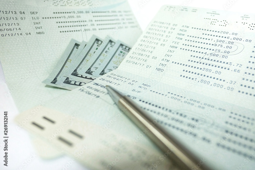 Bank account ballance passbook with pen and dollar banknote on white background Bank account ballance passbook with pen and dollar banknote on white background