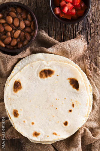Canvas Print Fresh homemade flour tortillas with cooked beans and fresh tomatoes on the side,