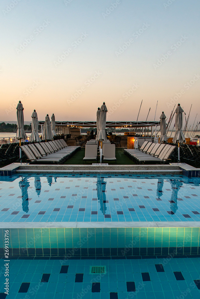 pool deck and parasols of luxury boat cruise ship in egypt luxor during dawn sunset