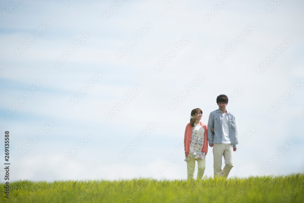草原を歩くカップル