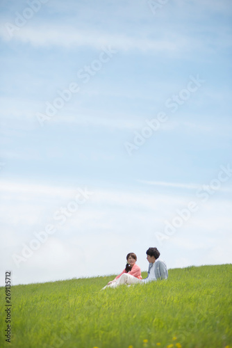 草原で談笑をするカップル