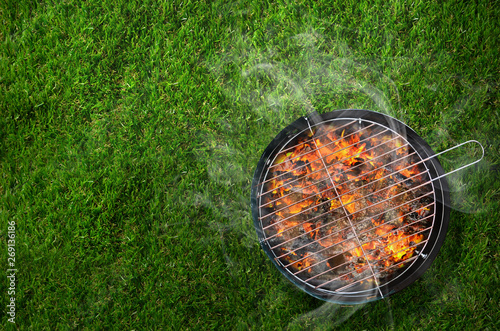 Burning barbecue on grass background