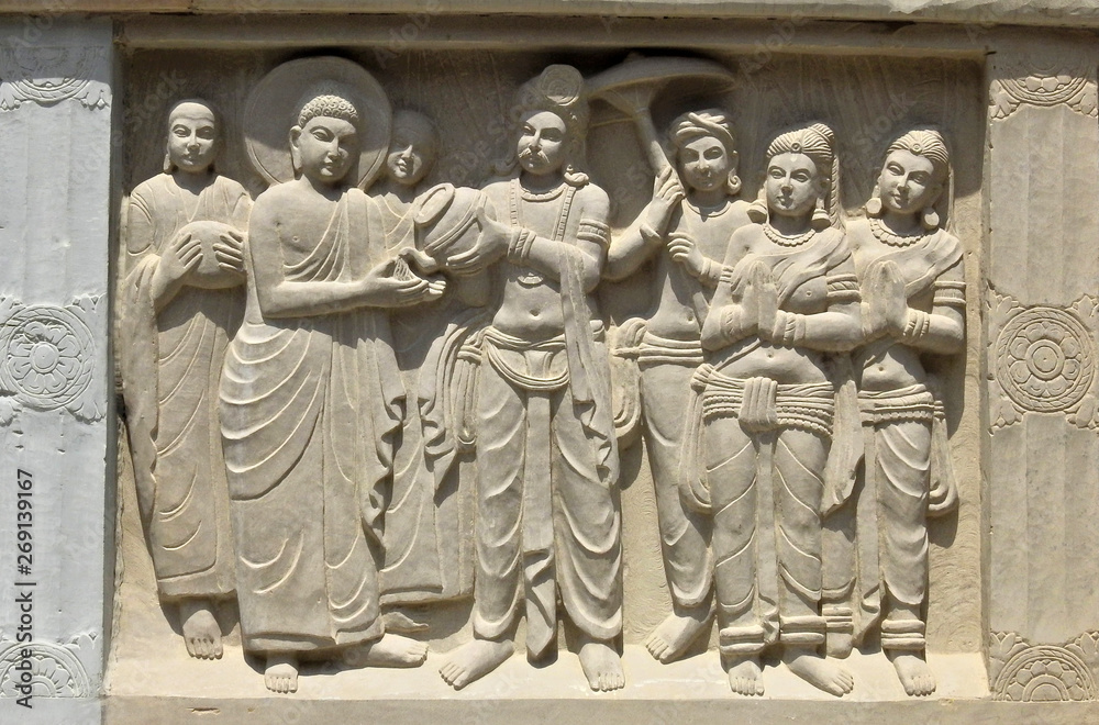 Naklejka premium View of stone carved wall art of Buddha receiving water from the king on the stupa, in Mahabodhi Vihara or temple and monastery