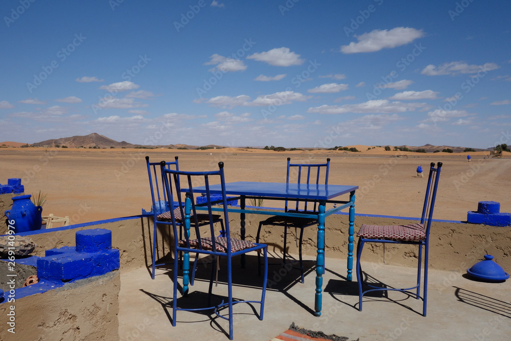 Blue table and chairs on a cafe terrace with a great view on the dunes near Merzouga, Morocco Blue table and chairs on a cafe terrace with a great view on the dunes near Merzouga, Morocco