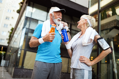 Mature couple drinks water to replenish energy and to hydrate