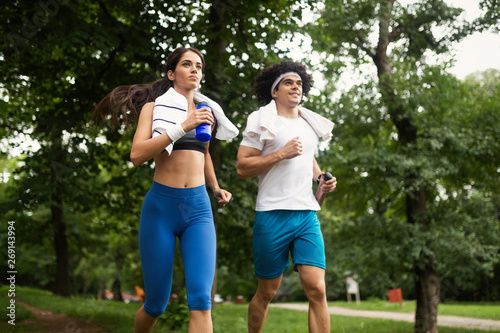 Happy young people jogging and exercising in nature