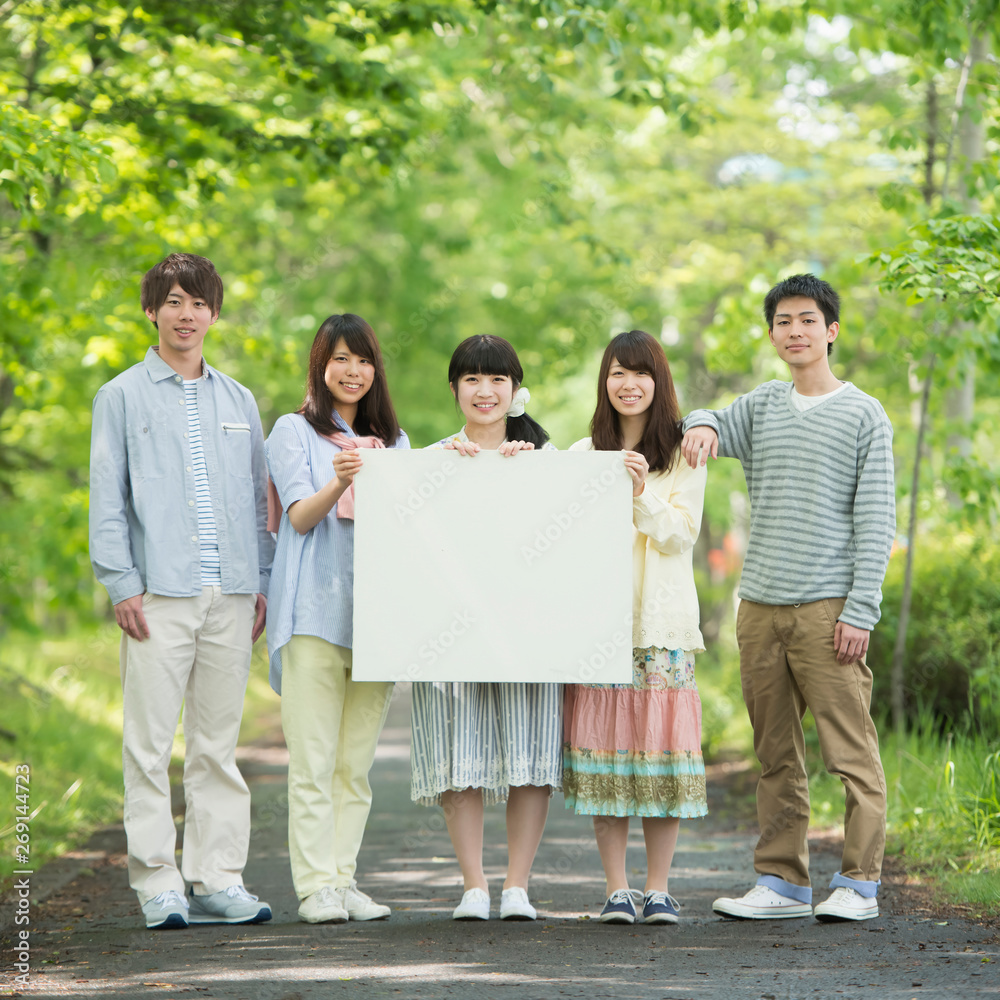 メッセージボードを持ち微笑む大学生