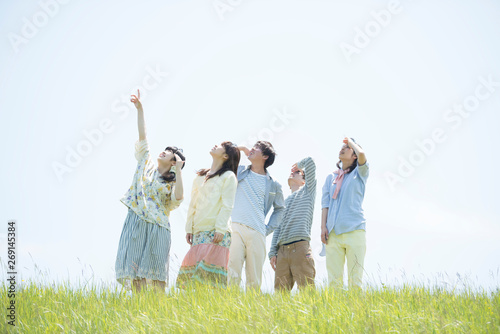 草原で空を見上げる大学生