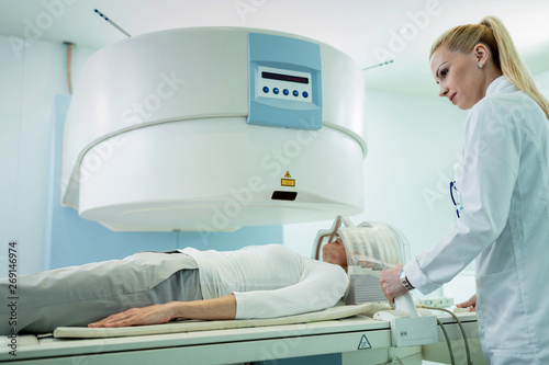 Female radiologist supervising patient during MRI scan in the hospital.