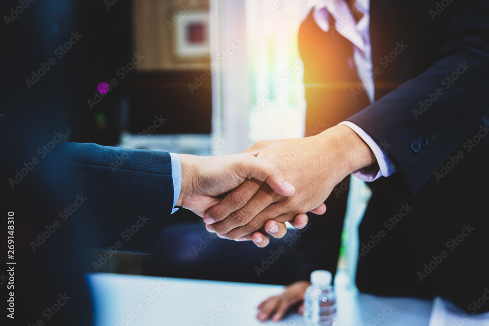 Successful business people shaking hands after closing a deal