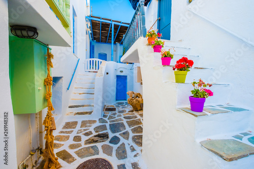 Beautiful white building's courtyard view with colorful flowerpots on stairs on the greek street © Ievgen Skrypko
