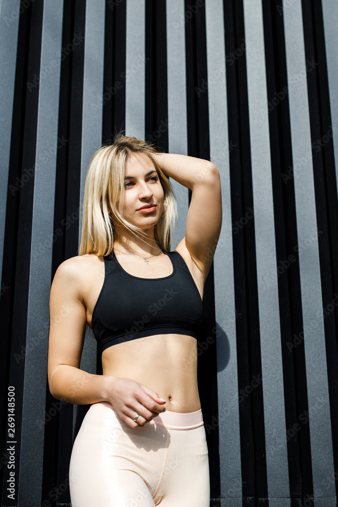 A young, sympathetic blond woman is actively spending time outdoors. The girl is dressed in sportswear. Exercise Outdoors. Health and benefits for the body A young, sympathetic blond woman is actively spending time outdoors. The girl is dressed in sportswear. Exercise Outdoors. Health and benefits for the body