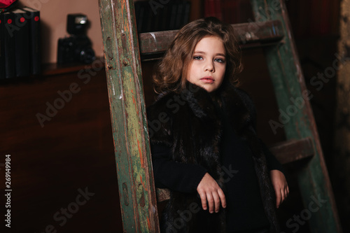 Little girl stand by the ladder in the library. Books © Aleksandr