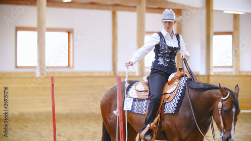 Elegant cowgirl on horse training opening the rope door © Video_StockOrg