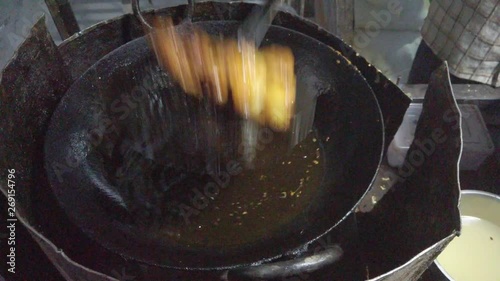 Close-up frying of Pakora, or pakoda, pakodi, fakkura, bhajiya, bhajji, bhaji or ponako, a fried snack fritters made with gram flour, of Indian subcontinent. slow motion Handheld stabilized gimbal 4k photo