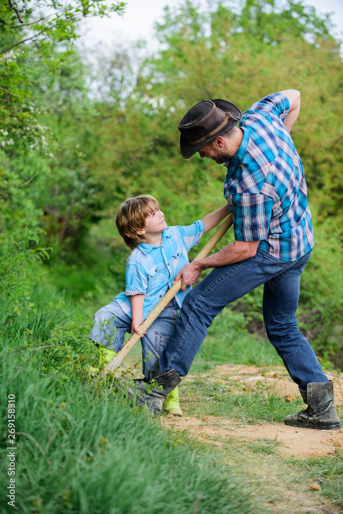 father and son planting family tree. rich natural soil. Eco farm. Ranch. small boy child help father in farming. new life. soils and fertilizers. happy earth day. Dig grounf with shovel. Little plant father and son planting family tree. rich natural soil. Eco farm. Ranch. small boy child help father in farming. new life. soils and fertilizers. happy earth day. Dig grounf with shovel. Little plant