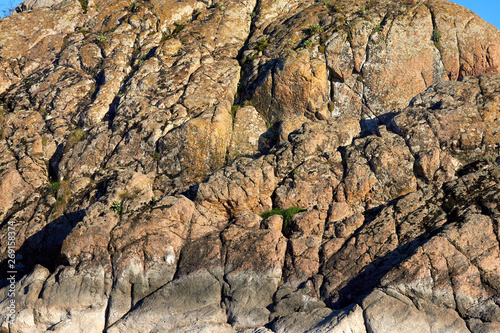 A fragment of a rock on a sunny day. Close-up of a fragment of rock. Autumn landscape with rock