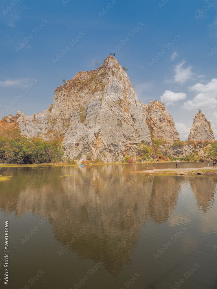 view morning of Khao Ngu Stone Park, beautiful big rock mountain with reflection on surface of water and blue sky background, famous attraction in Ratchaburi, Thailand.