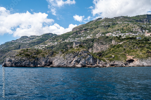 Positano, Salerno, Campania, Italy, Europe : view of Amalfi from the sea on a boat on Amalfi Coast. Wake of a ship with a marine village in the background. Tower (watchtower) of Capo di Conca