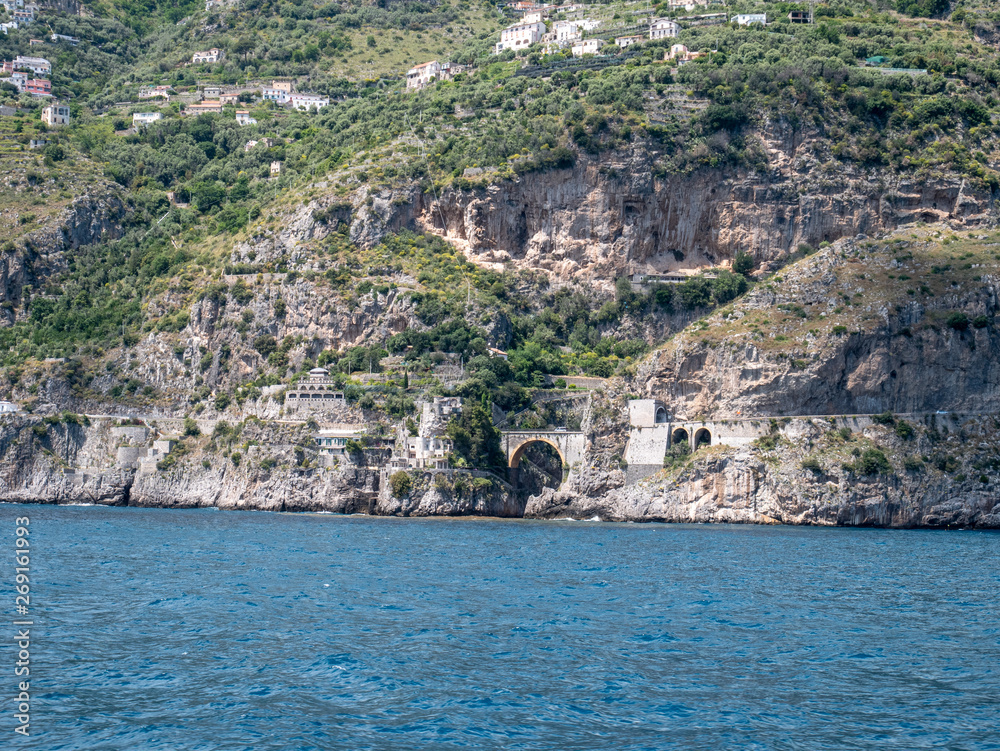 Positano, Salerno, Campania, Italy, Europe - may 19 2019: view of Furore fjord from the sea on a boat on Amalfi Coast. Wake of a ship with a marine village in the background