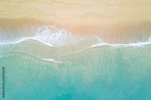 Fotografiet Aerial view of turquoise ocean wave reaching the coastline