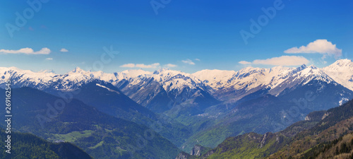 panoramic view on snowy peak mountains under blue sky