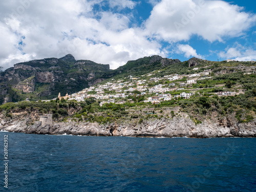 Positano, Salerno, Campania, Italy, Europe - may 19 2019: view of Praiano from the sea on a boat leaving the port on Amalfi Coast. Wake of a ship with a marine village in the background