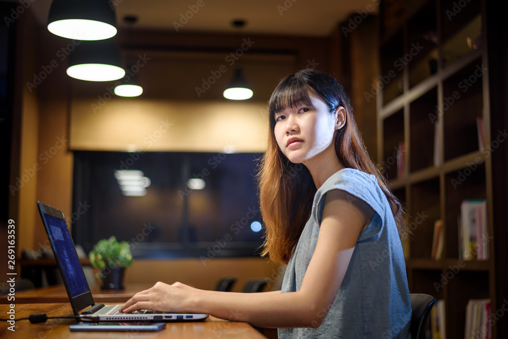 Happy Beautiful Asian Student woman working on  laptop in  modern library  room