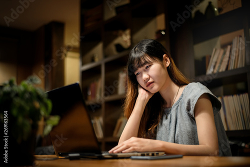 Happy Beautiful Asian Student woman working on laptop in modern library room