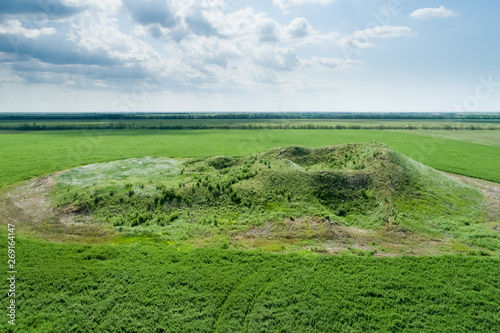 Scenic view of the burial mound of the Scythian king in a green field. Aerial view. photo