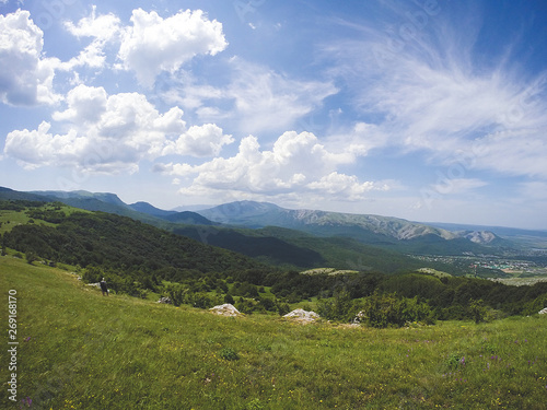 Beautiful summer sunny mountain landscape with a clear blue sky with clouds background. Crimean mountains