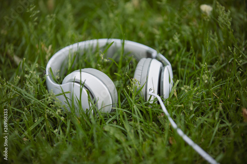 White headphone in the grass, sound concept
