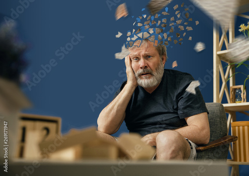 Drown image of losing of mind. Old bearded man with alzheimer desease sitting and suffering from headache. Illness, memory loss due to dementia, healthcare, neurological disorder, depression.