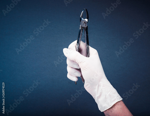 Hand in glove holding medical flatterns on dark blue background photo