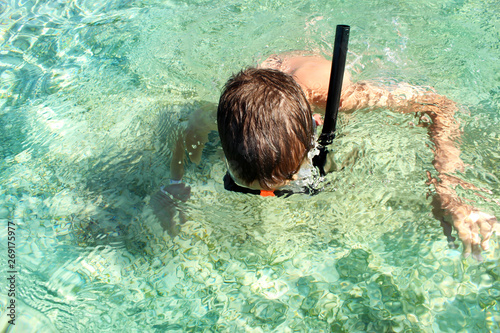 The child dives with a mask into the sea.
