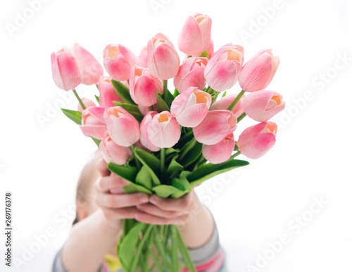 Young person holding majestic bouquet of pink tulips, isolated on white background