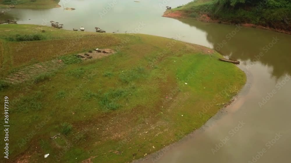 Aerial over Lô River riverbank with wooden canoes parked in the shallow Aerial over Lô River riverbank with wooden canoes parked in the shallow