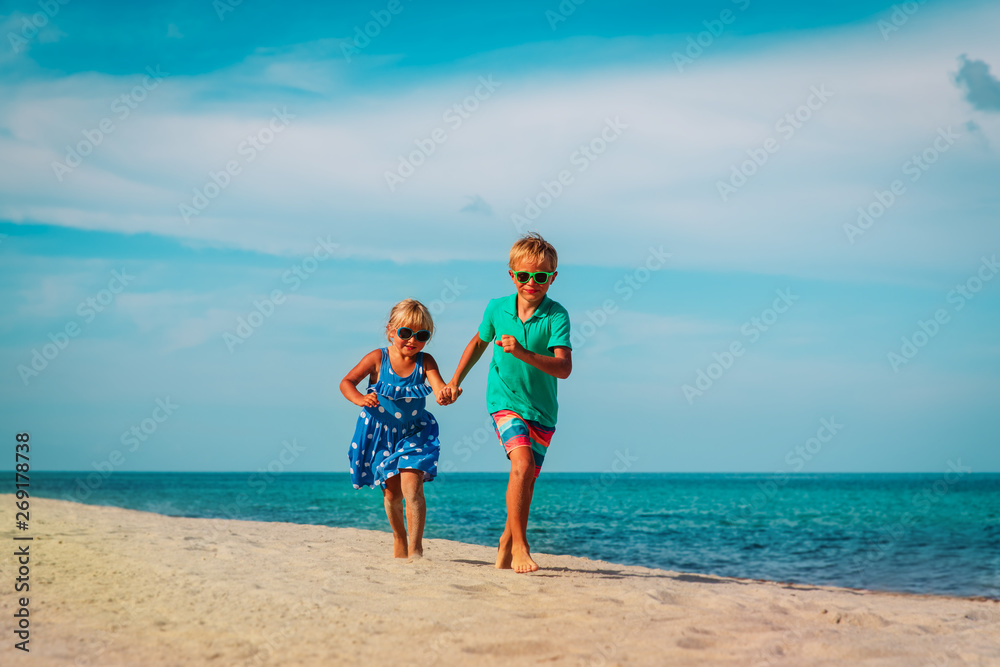 happy kids- boy and girl running at beach