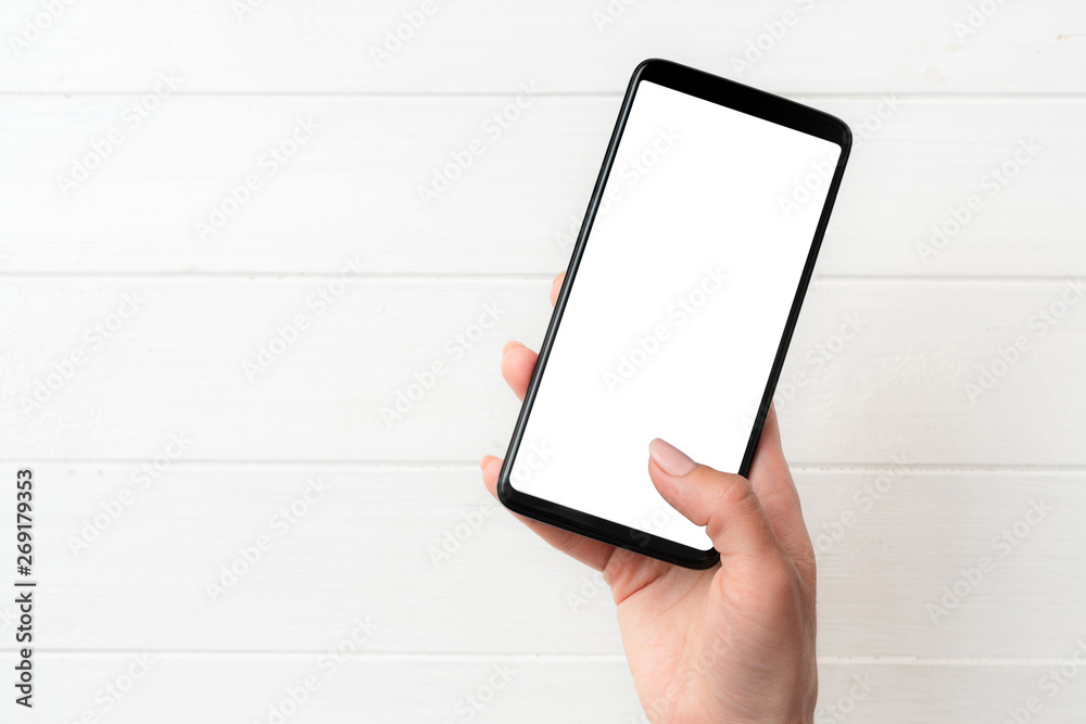 User holding modern smartphone with white screen in hand User holding modern smartphone with white screen in hand