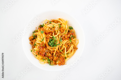 Spaghetti bolognese on a white plate. Italian cuisine concept, food ingredients. Flat lay. Top view
