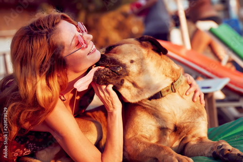 Dog licking the face of hipster woman